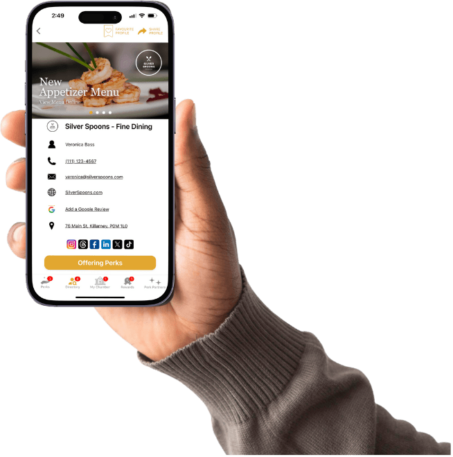 A hand holding the Chamber Perks app open to a member profile and available perks
